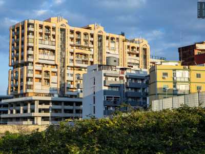 ...trafficata arteria segnata da enormi condomini intervellati da garage e supermercati